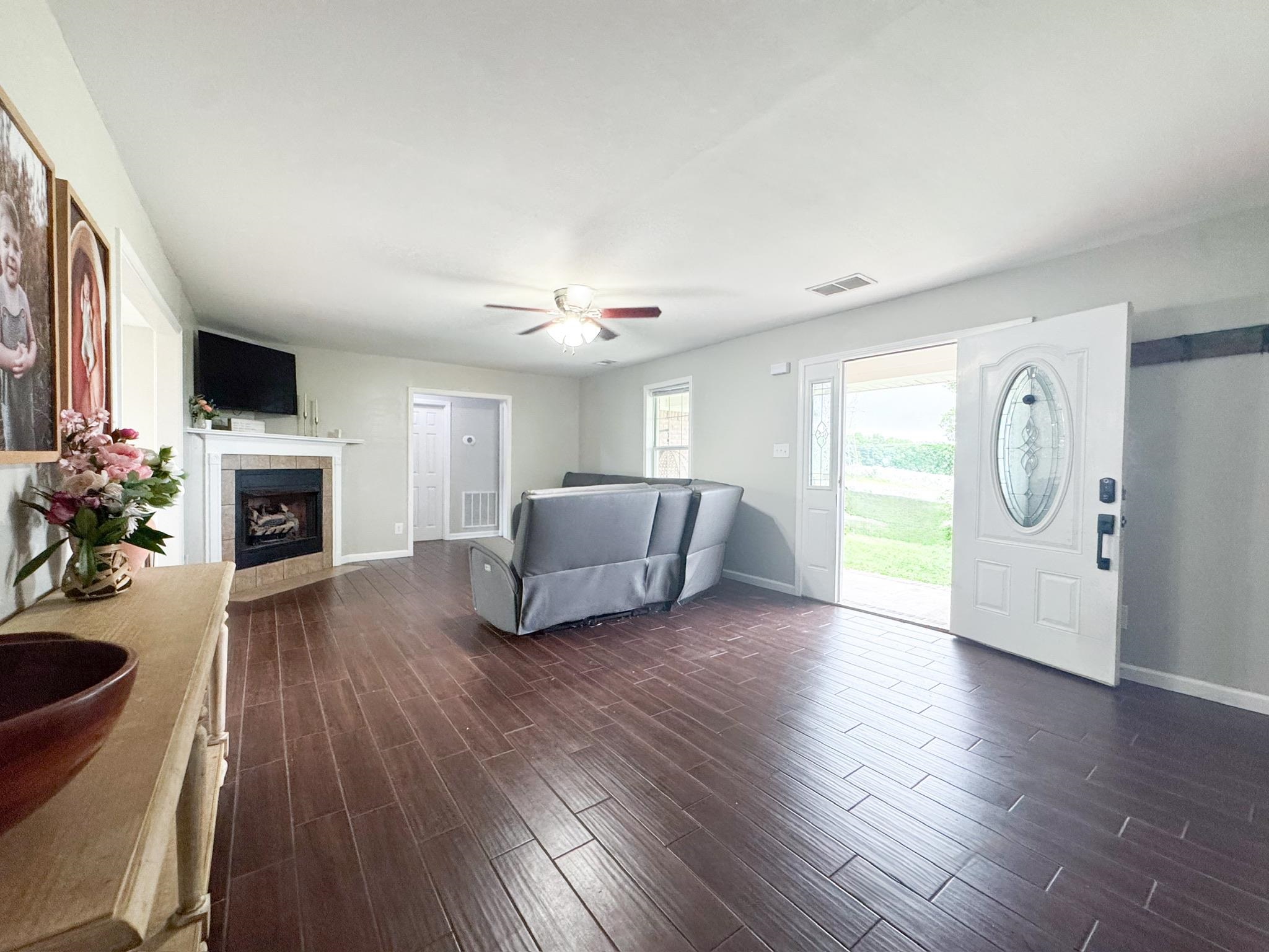 4776 Campground Road Munford, TN 38058 - Photo 2 of 25 a living room with furniture a fireplace and a flat screen tv