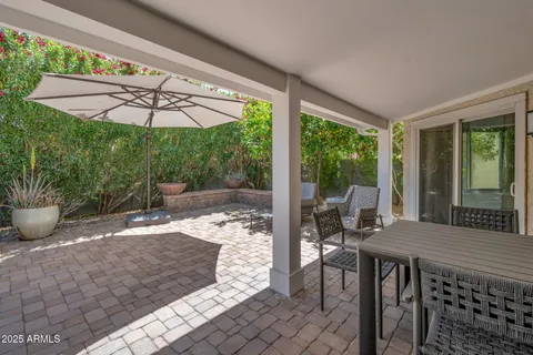 a view of a patio with table and chairs potted plants with wooden fence