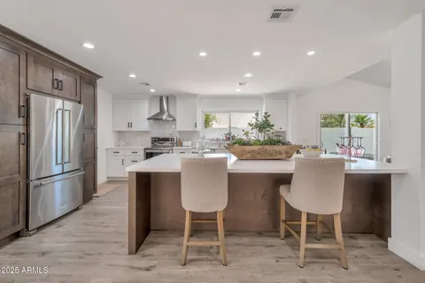 a kitchen with stainless steel appliances granite countertop a white cabinets and wooden floor