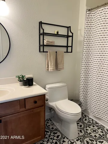 a living room with furniture kitchen view and a wooden floor