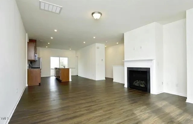 a view of empty room with wooden floor and fireplace