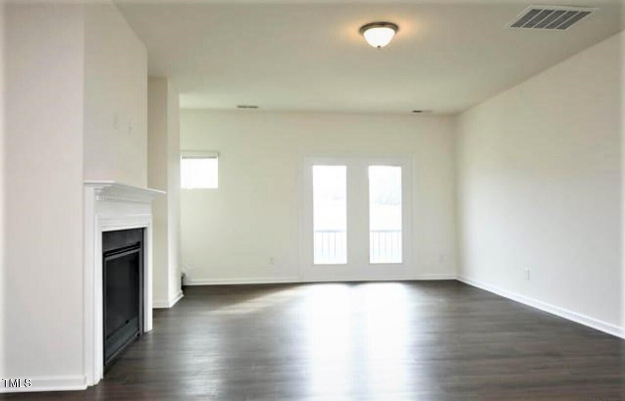 4121 Mahal Avenue Cary, NC 27519 - Photo 13 of 33 an empty room with wooden floor and fireplace
