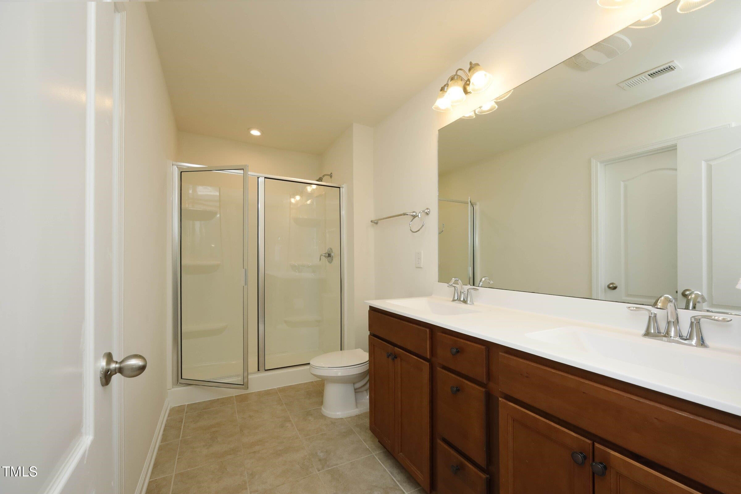 4121 Mahal Avenue Cary, NC 27519 - Photo 22 of 33 a spacious bathroom with a double vanity sink toilet mirror and shower