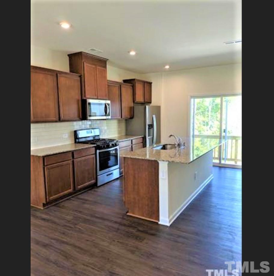 4121 Mahal Avenue Cary, NC 27519 - Photo 5 of 33 a large kitchen with stainless steel appliances granite countertop a stove a sink and a refrigerator