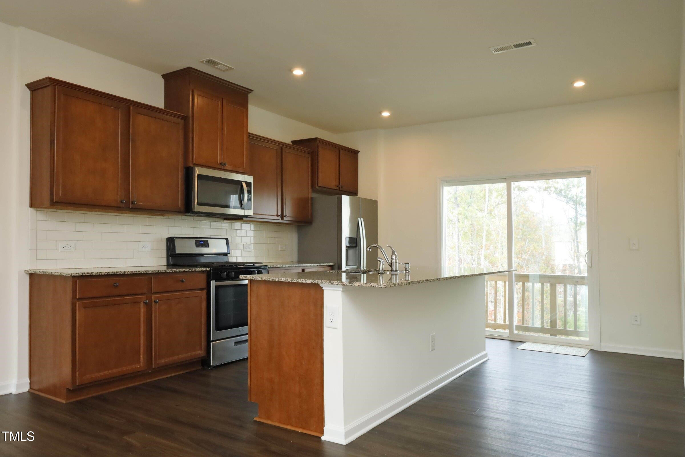 4121 Mahal Avenue Cary, NC 27519 - Photo 10 of 33 a kitchen with stainless steel appliances granite countertop a stove a sink a refrigerator a microwave a sink and cabinets