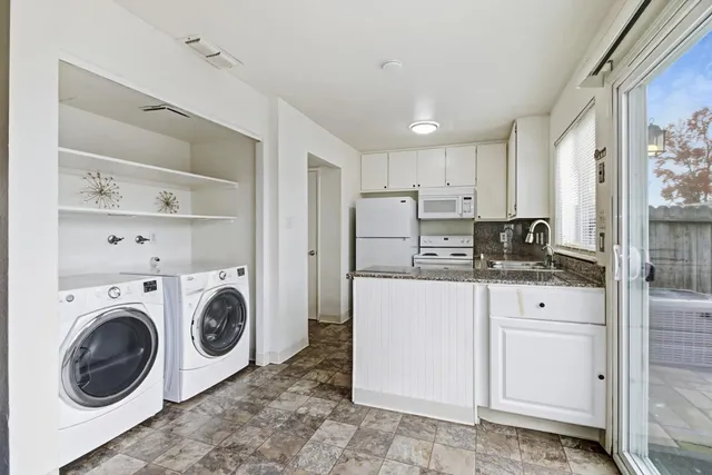 a utility room with cabinets washer and dryer