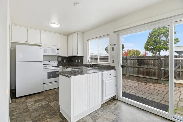 a kitchen with white cabinets and refrigerator