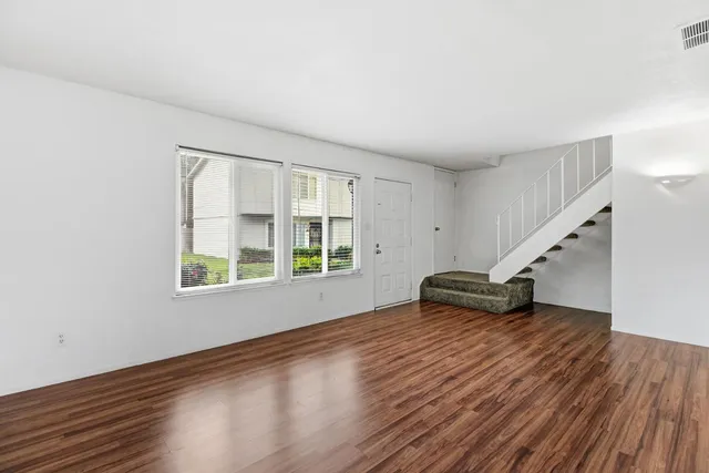 wooden floor in an empty room with a window