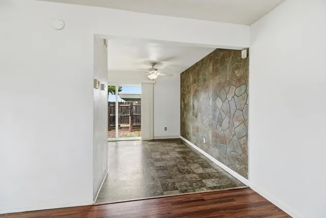 a view of a hallway with wooden floor and a large window