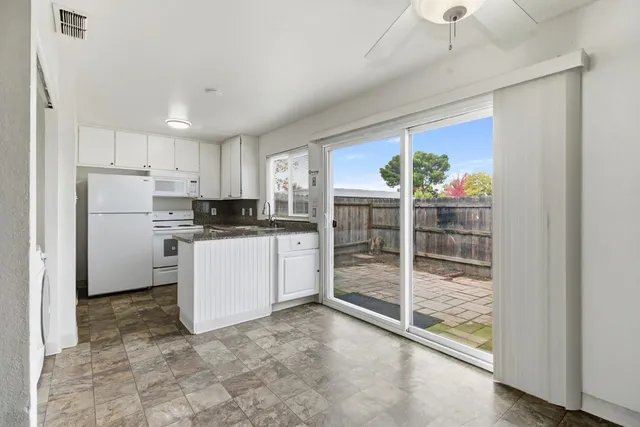 a kitchen with white cabinets and refrigerator