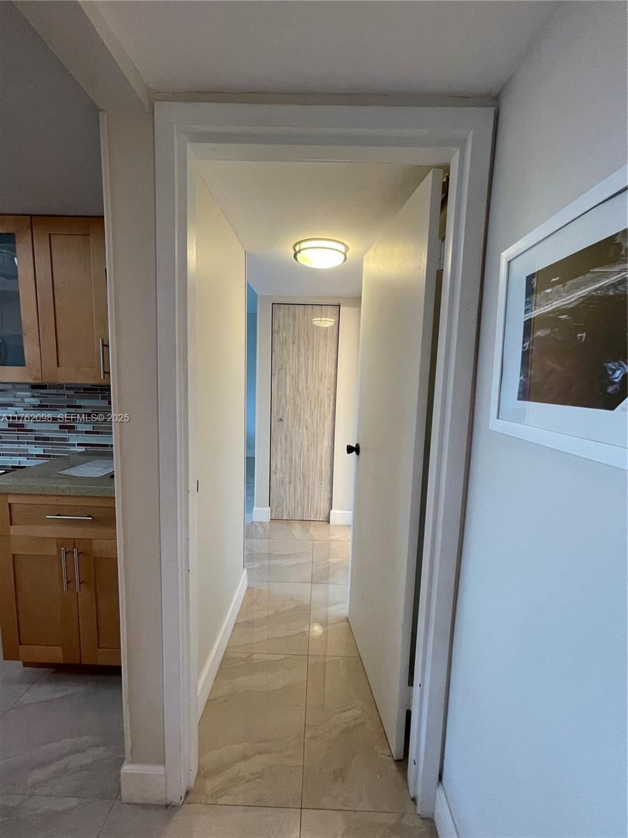 2655 Collins Avenue, Unit 1906 Miami Beach, FL 33140 - Photo 11 of 35 a view of hallway with cabinets and wooden floor
