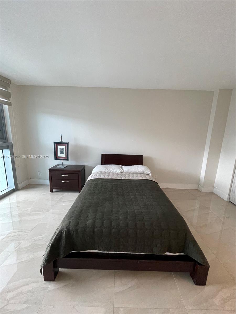 2655 Collins Avenue, Unit 1906 Miami Beach, FL 33140 - Photo 14 of 35 a bedroom with a bed and window