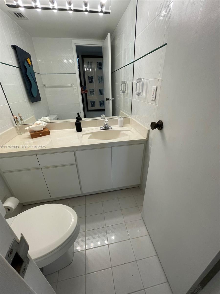 2655 Collins Avenue, Unit 1906 Miami Beach, FL 33140 - Photo 33 of 35 a bathroom with a sink a toilet and mirror