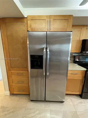 a living room with stainless steel appliances kitchen island granite countertop furniture a rug and a window