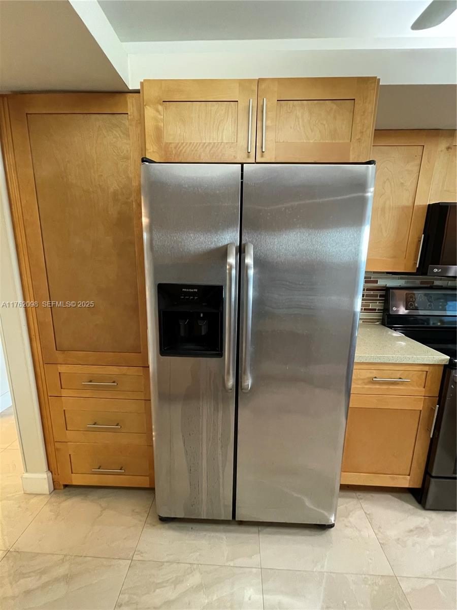 2655 Collins Avenue, Unit 1906 Miami Beach, FL 33140 - Photo 5 of 35 a kitchen with a refrigerator