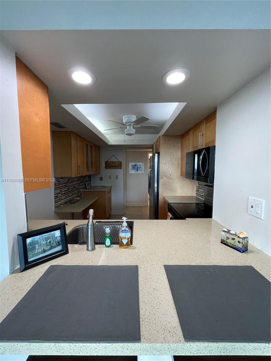 2655 Collins Avenue, Unit 1906 Miami Beach, FL 33140 - Photo 10 of 35 a living room with stainless steel appliances kitchen island granite countertop furniture a rug and a window