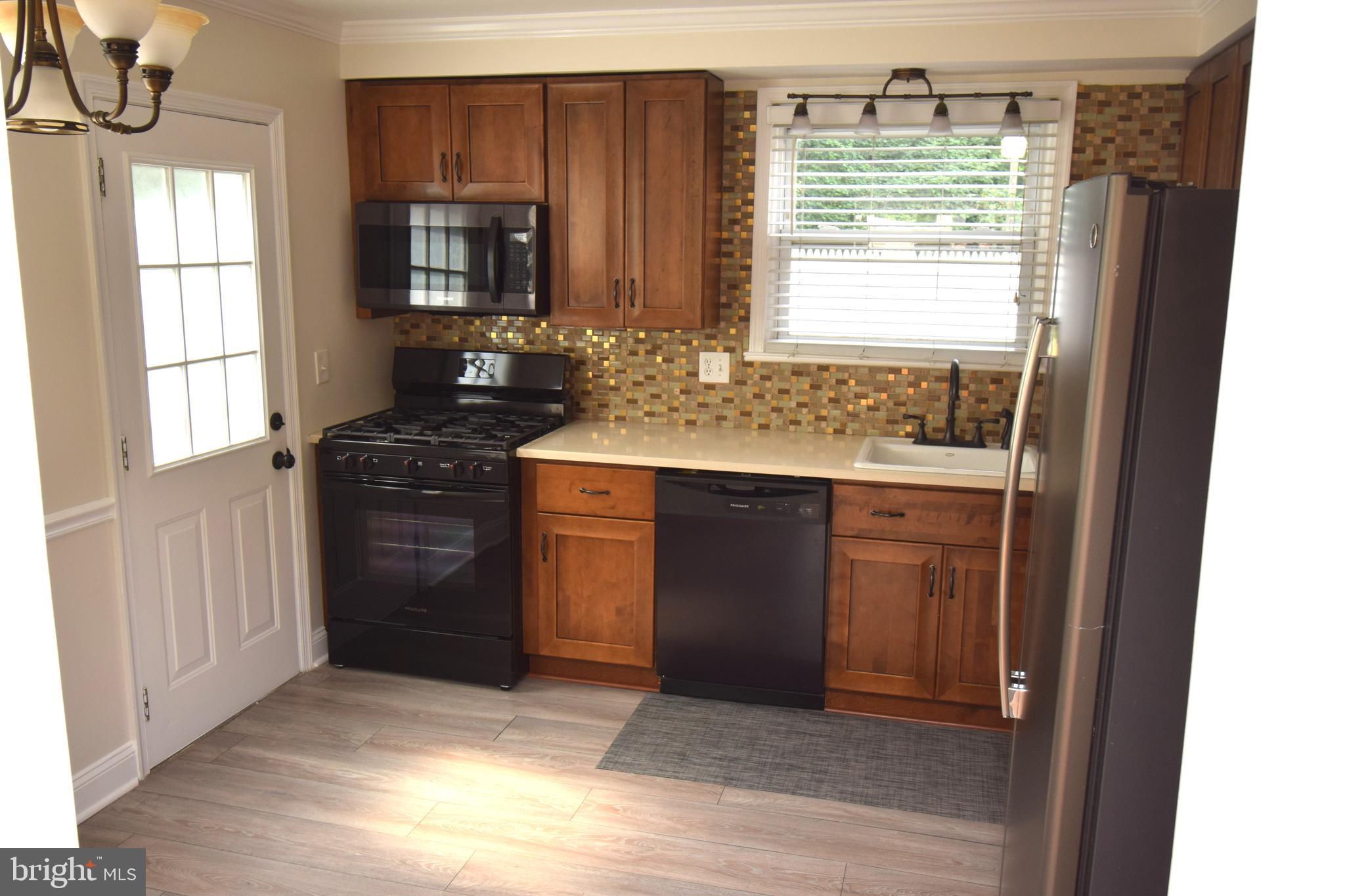 1354 Sudvale Road Pikesville, MD 21208 - Photo 4 of 17 a kitchen with a stove a sink and a window