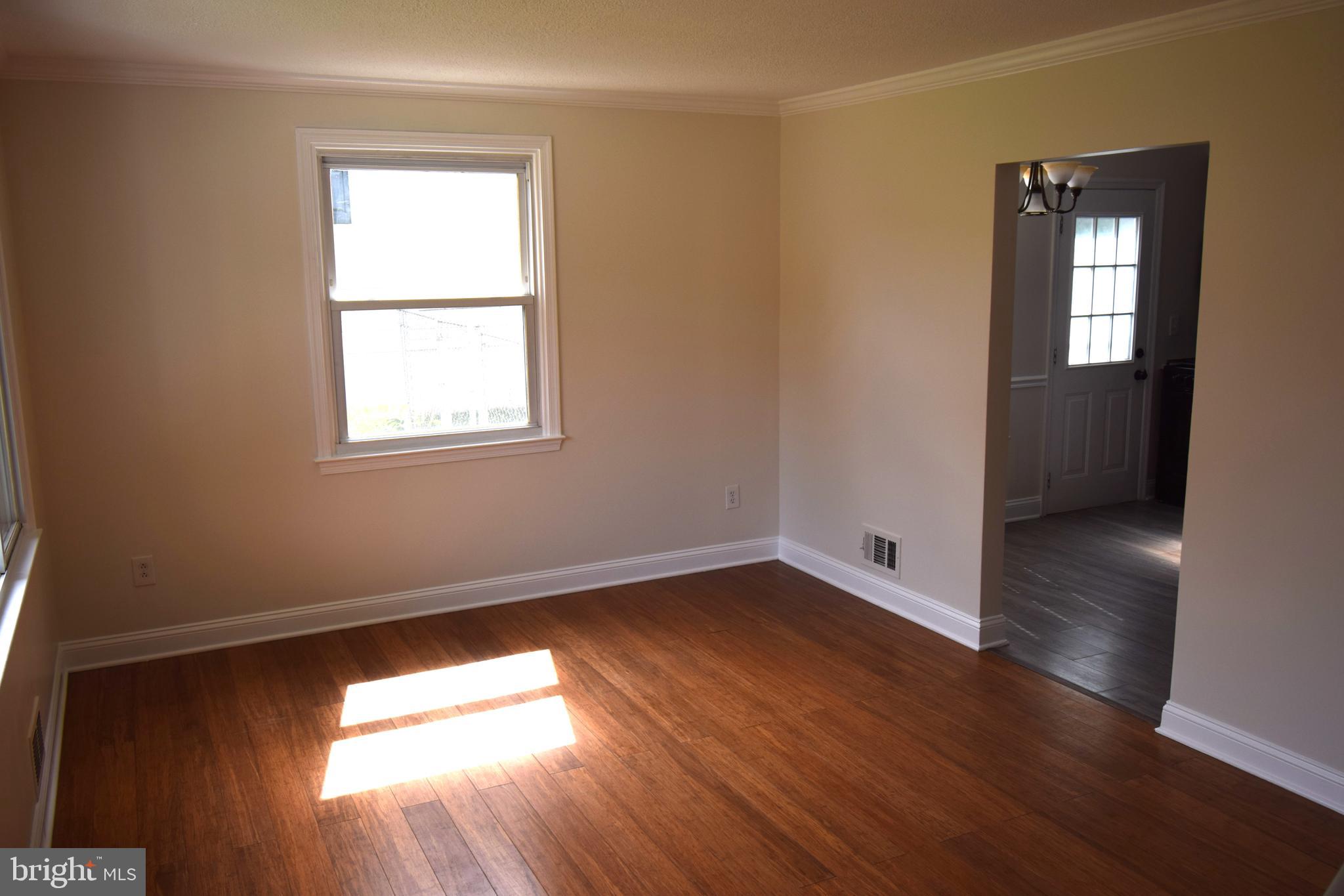 1354 Sudvale Road Pikesville, MD 21208 - Photo 5 of 17 an empty room with wooden floor and windows