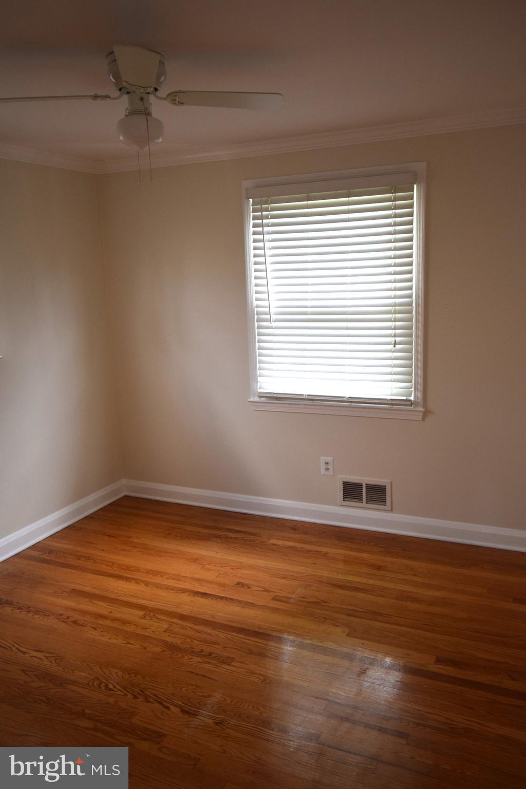 1354 Sudvale Road Pikesville, MD 21208 - Photo 6 of 17 an empty room with wooden floor and windows
