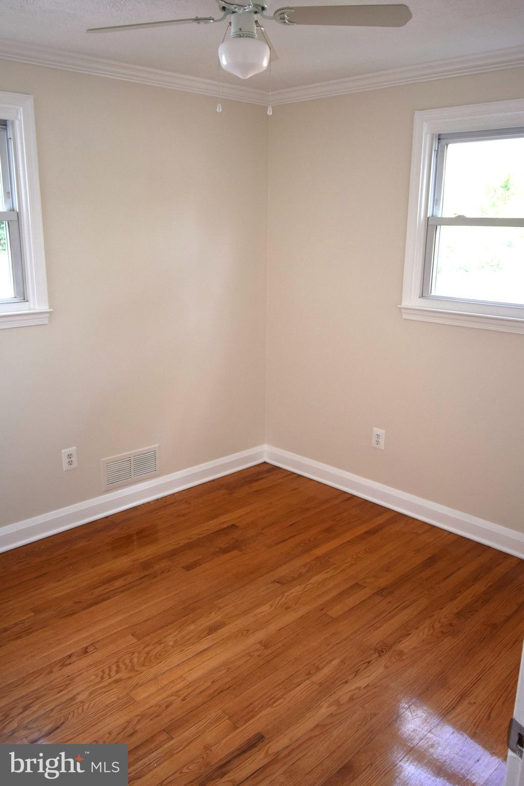 1354 Sudvale Road Pikesville, MD 21208 - Photo 9 of 17 a view of an empty room with wooden floor and a window