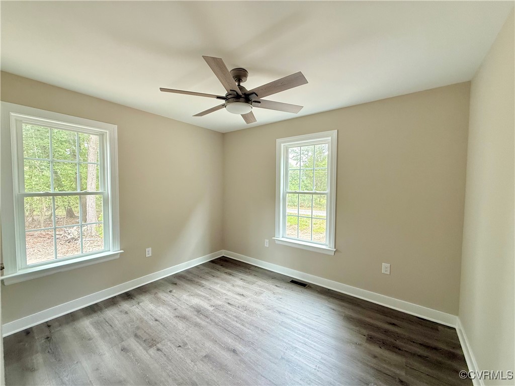 26 Tupelo Street Deltaville, VA 23043 - Photo 16 of 38 a view of an empty room with a window and wooden floor