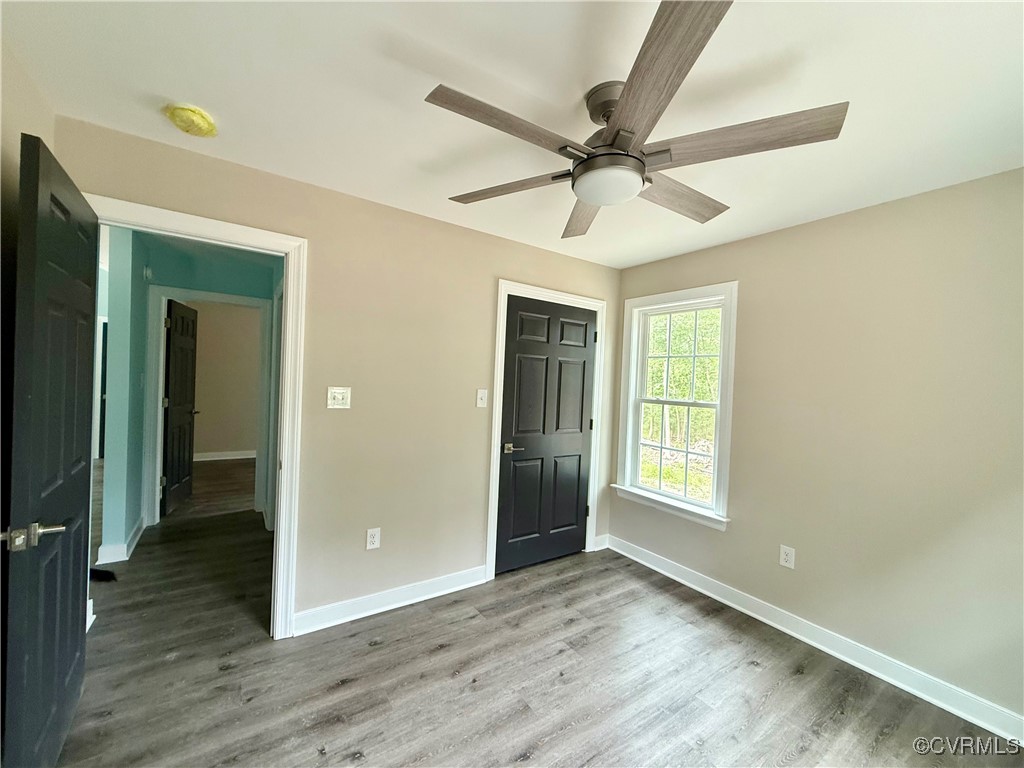 26 Tupelo Street Deltaville, VA 23043 - Photo 17 of 38 an empty room with wooden floor fan and windows