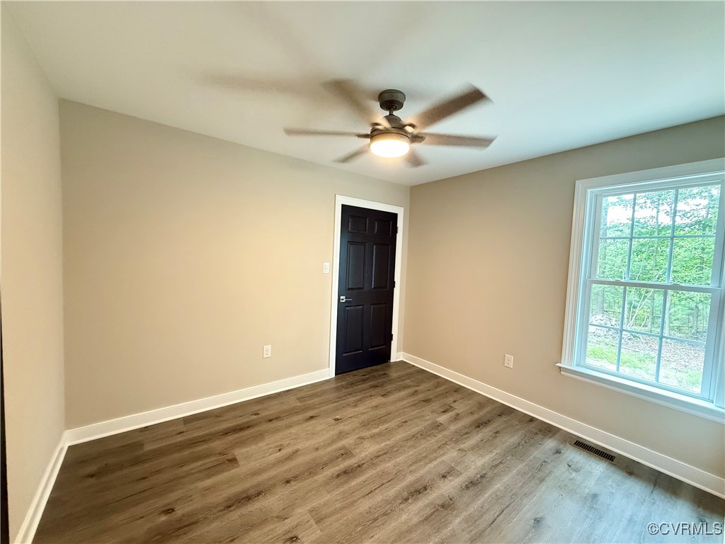 26 Tupelo Street Deltaville, VA 23043 - Photo 18 of 38 a view of an empty room with wooden floor and a window
