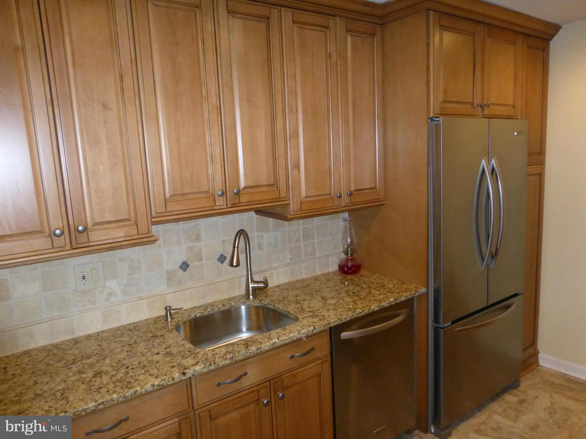 9317 Perglen Road Baltimore, MD 21236 - Photo 5 of 23 a kitchen with stainless steel appliances granite countertop a refrigerator sink and cabinets