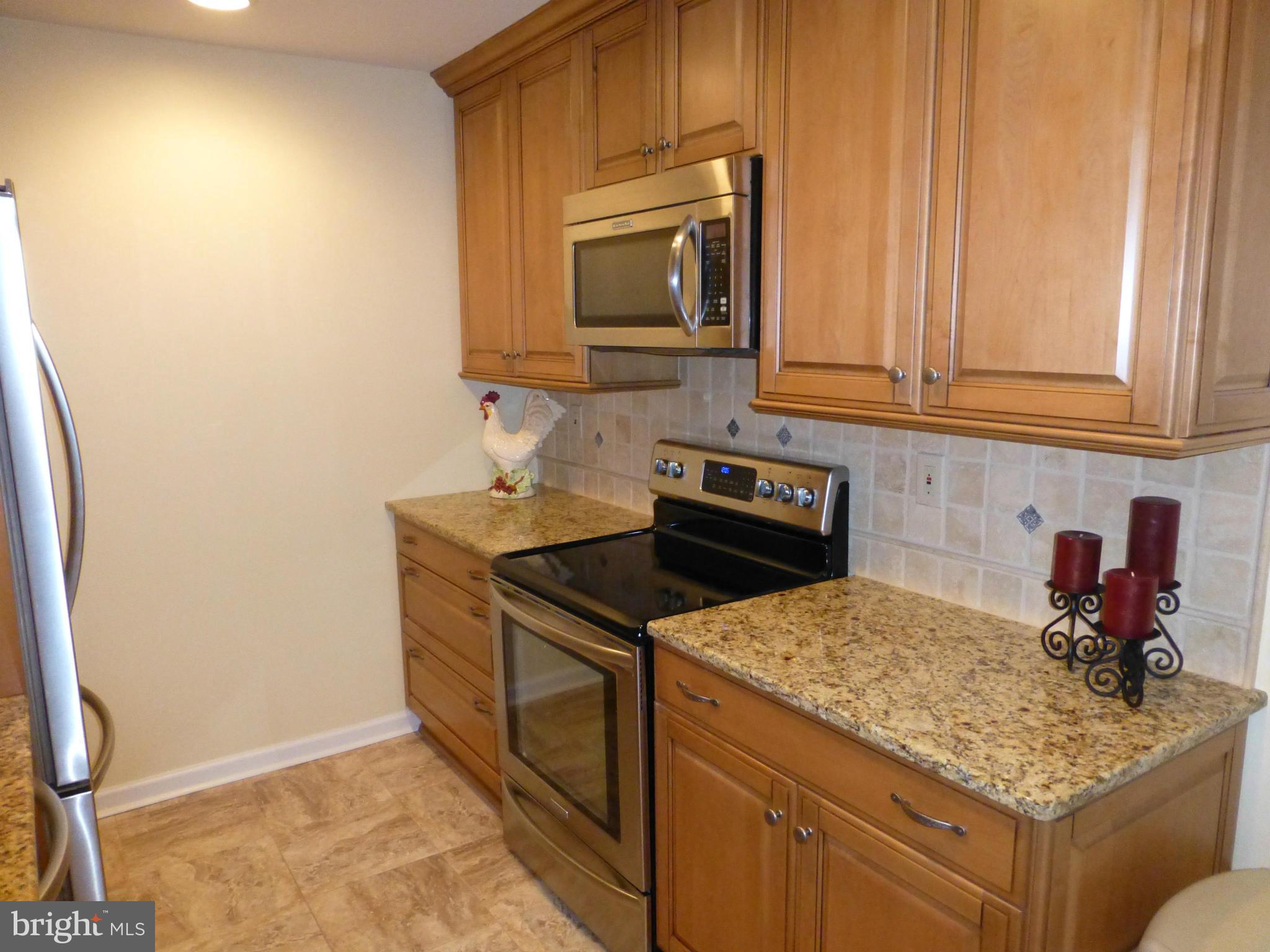 9317 Perglen Road Baltimore, MD 21236 - Photo 6 of 23 a kitchen with granite countertop a sink stove and microwave