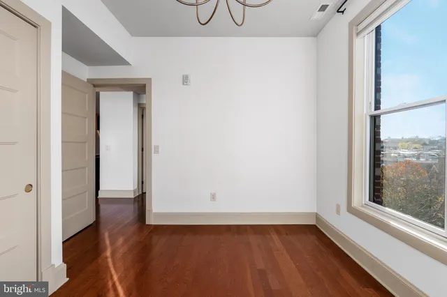 a view of a room with wooden floor and a window