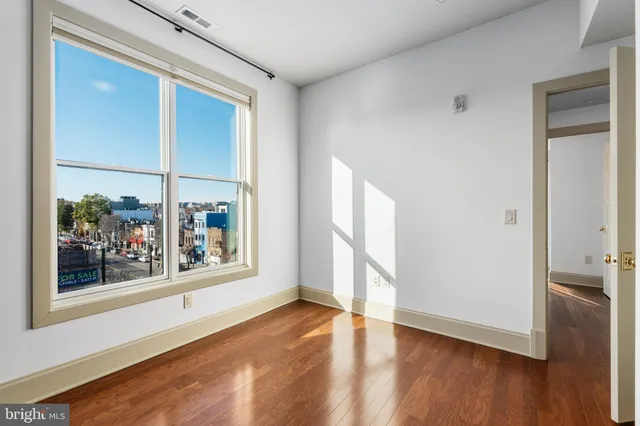 an empty room with wooden floor and a window