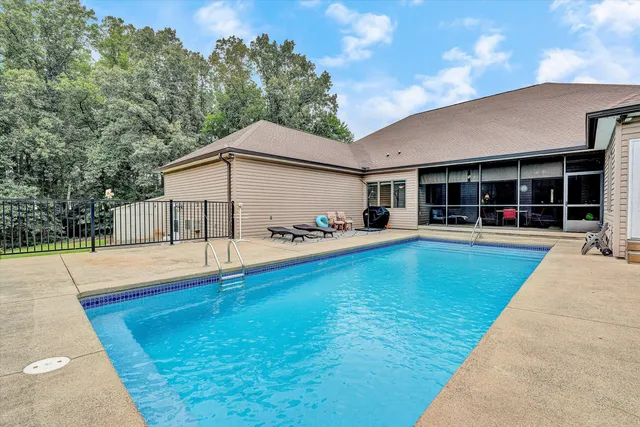 a view of a house with pool and sitting area