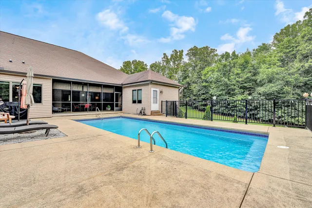 a view of house with swimming pool and view of a swimming pool