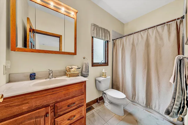 a bathroom with a granite countertop sink mirror vanity and toilet