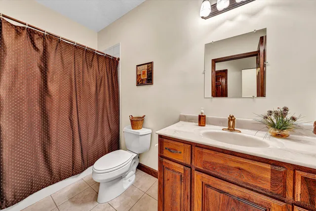 a bathroom with a granite countertop sink mirror vanity and toilet