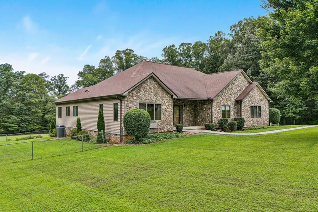 a front view of a house with a garden and trees