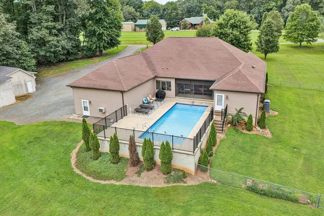 a aerial view of a house with swimming pool and a yard
