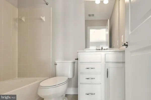 a bathroom with a sink a toilet a mirror and shower