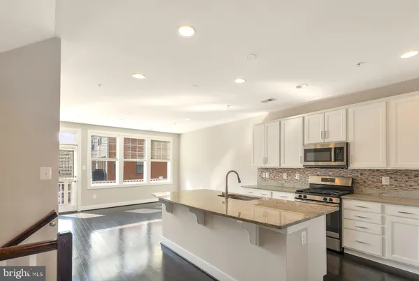 a kitchen with stainless steel appliances granite countertop a stove a sink and a microwave