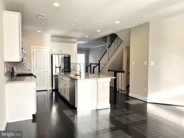 a kitchen with a refrigerator and a stove top oven
