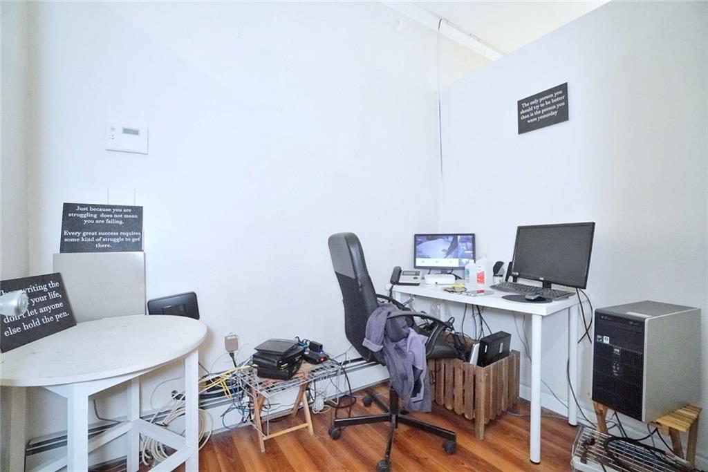 533 Sutter Avenue Brooklyn, NY 11207 - Photo 10 of 18 a view of a workspace with furniture and wooden floor