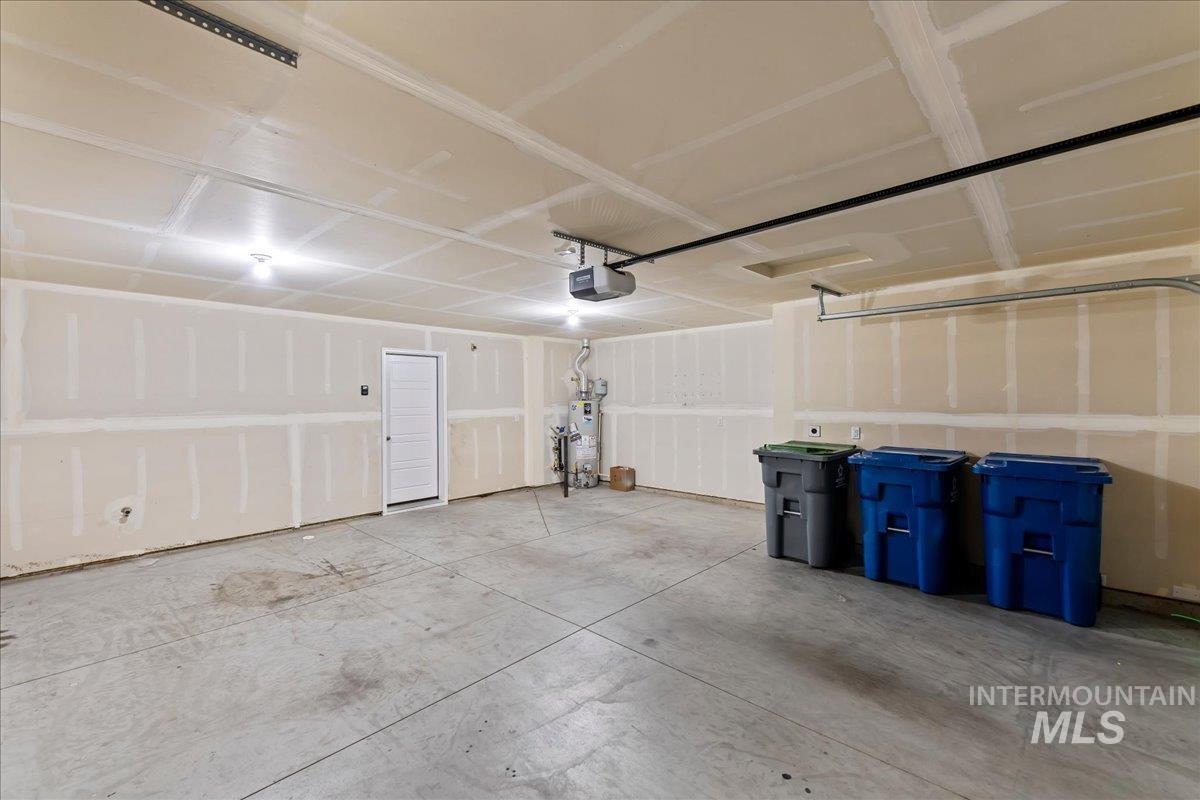 12535 West Victory Road Boise, ID 83709 - Photo 23 of 25 Spacious garage with exposed framing, concrete flooring, and an interior access door