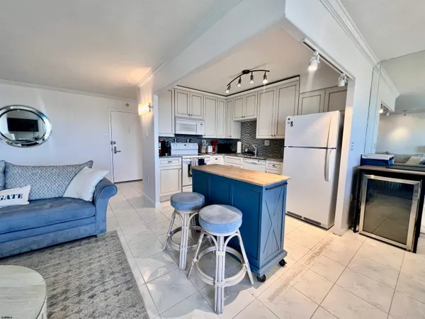 a kitchen with stainless steel appliances kitchen island granite countertop a refrigerator a stove a sink and a oven