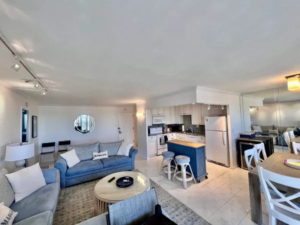 a living room with furniture and kitchen view