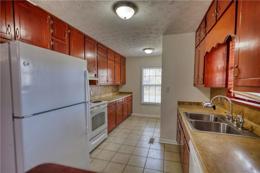 2475 Nugget Drive Southwest Conyers, GA 30094 - Photo 18 of 47 a kitchen with stainless steel appliances granite countertop a refrigerator a sink and a stove