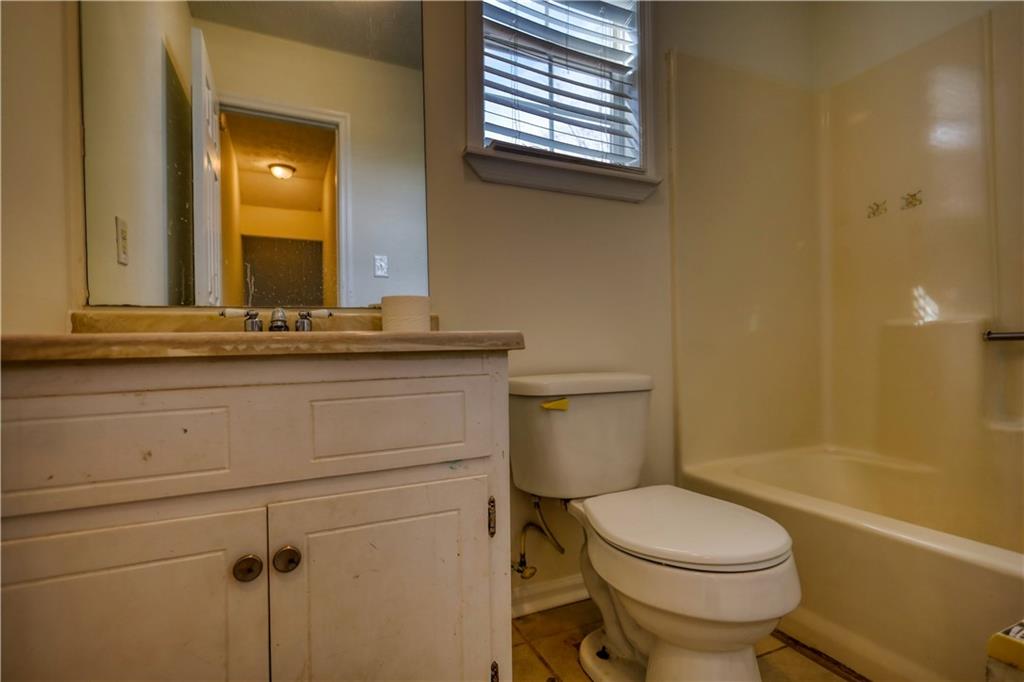 2475 Nugget Drive Southwest Conyers, GA 30094 - Photo 34 of 47 a bathroom with a granite countertop toilet a sink and a bathtub