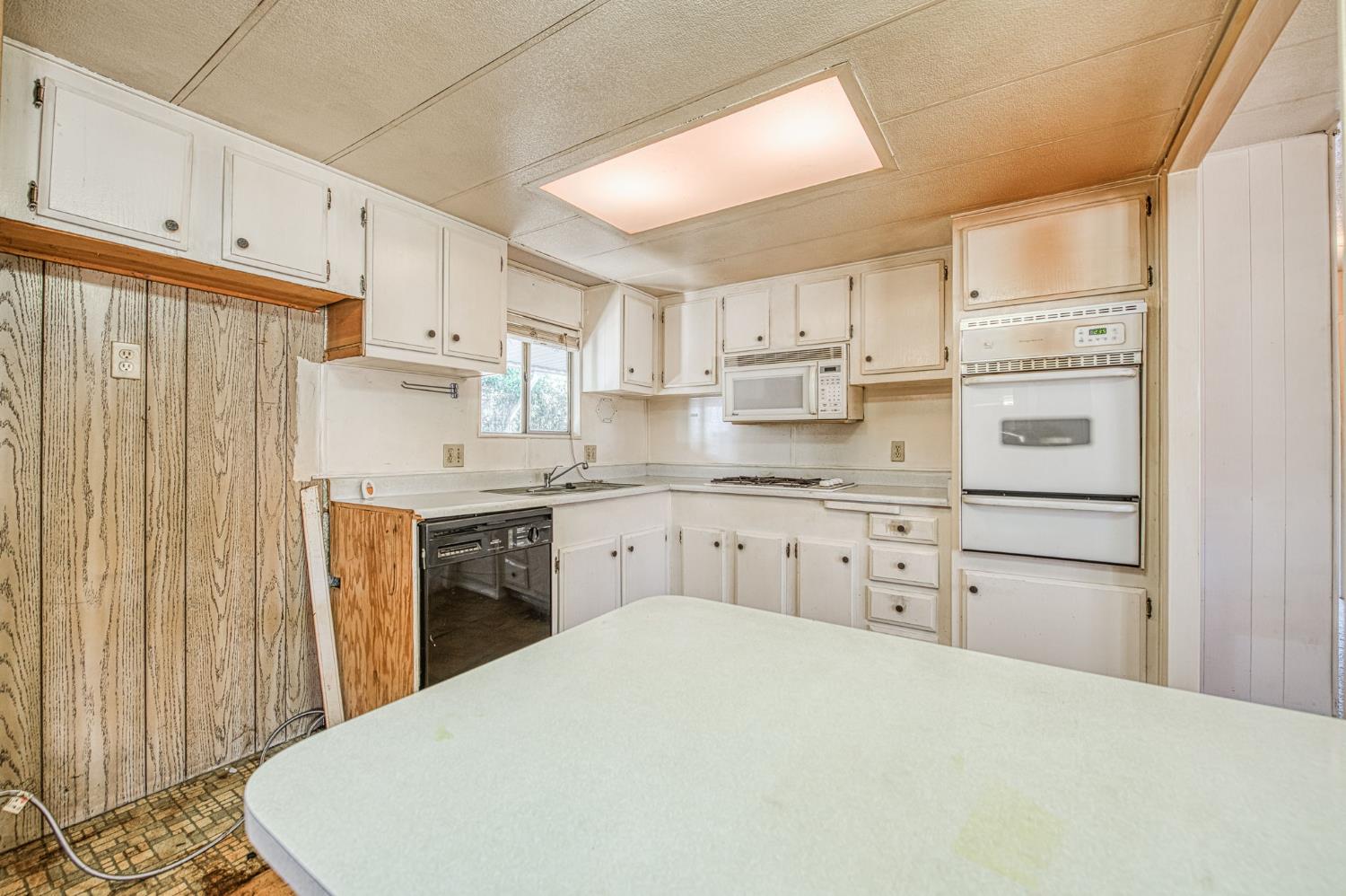 1300 West Olson Avenue, Unit 75 Reedley, CA 93654 - Photo 14 of 40 a kitchen with cabinets appliances and a window