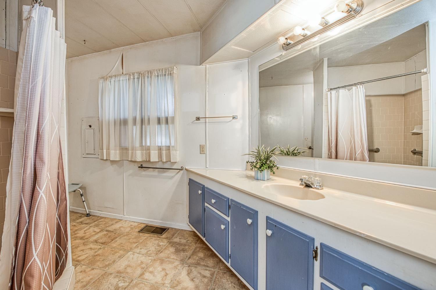 1300 West Olson Avenue, Unit 75 Reedley, CA 93654 - Photo 20 of 40 a spacious bathroom with a double vanity sink and a mirror