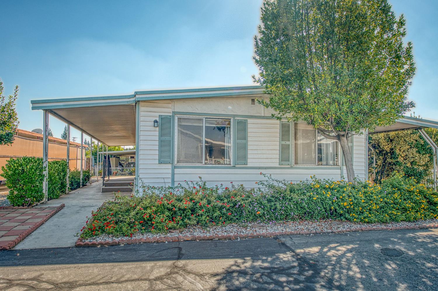 1300 West Olson Avenue, Unit 75 Reedley, CA 93654 - Photo 2 of 40 a front view of a house with garden