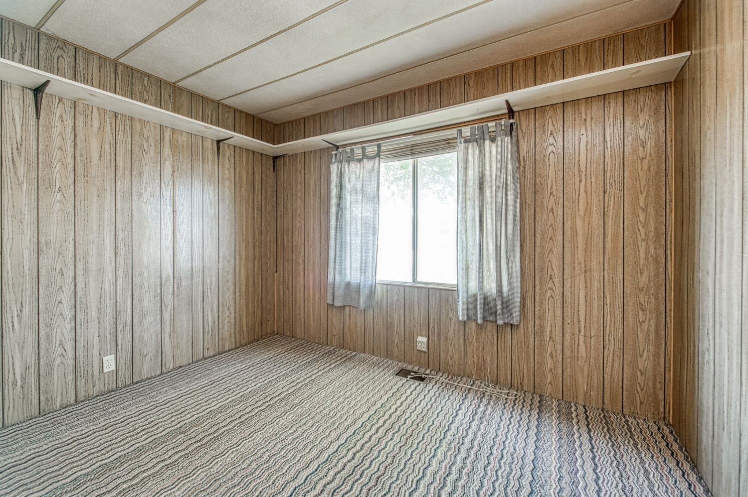 1300 West Olson Avenue, Unit 75 Reedley, CA 93654 - Photo 24 of 40 a view of an empty room with wooden floor and a window